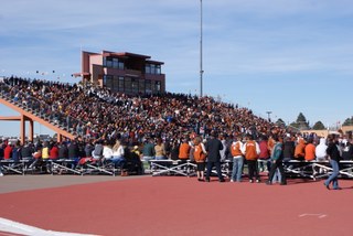 The stadium with the bleachers filled with sports fans.