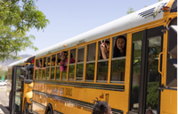 students making peace signs in an APS bus