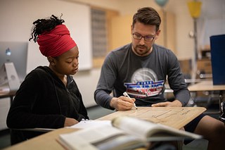 high school student studying with teacher