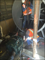 Two M&O employees replacing a large motor
