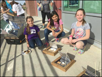 Students smiling with their handmade solar ovens