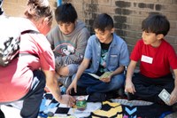 Three students showcase their items at the Mercado.