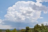 Very large fluffy white rain cloud over landscape