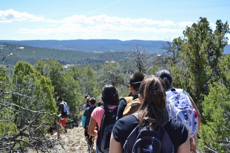 Students walking down hill with view of mountains and forest