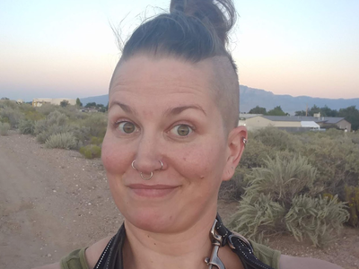 SMNHC admin assistant Maggie Price on trail with mountains in the background