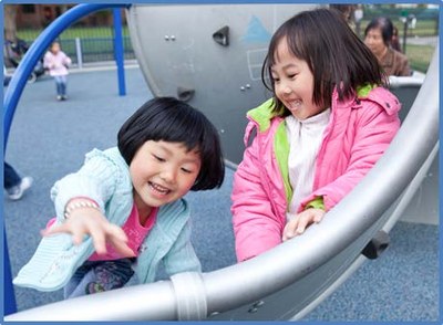 Two girls laughing and playing on a slide